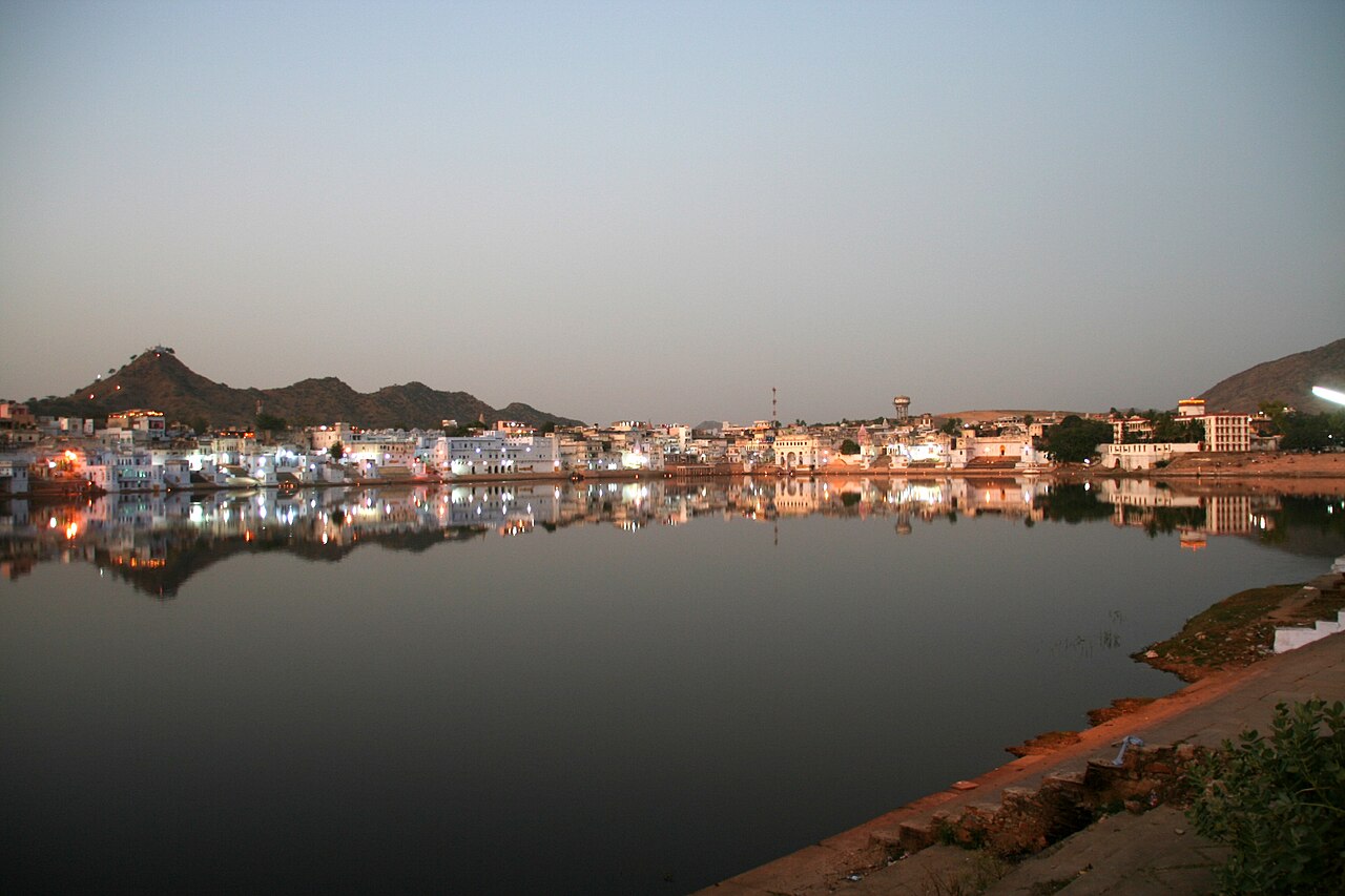 Sacred Pushkar Lake surrounded by white bathing ghats and desert hills in Rajasthan