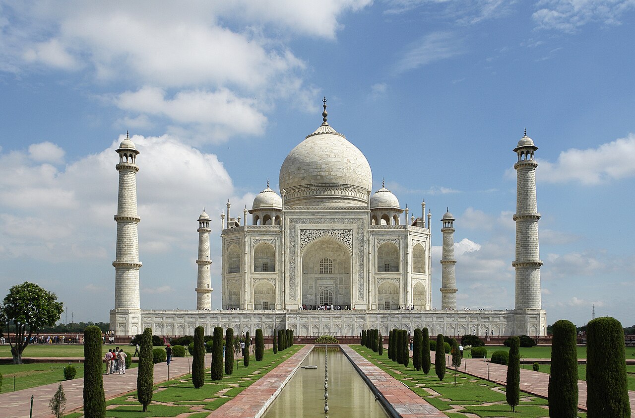 Taj Mahal ivory-white marble mausoleum reflecting in the water gardens of Agra